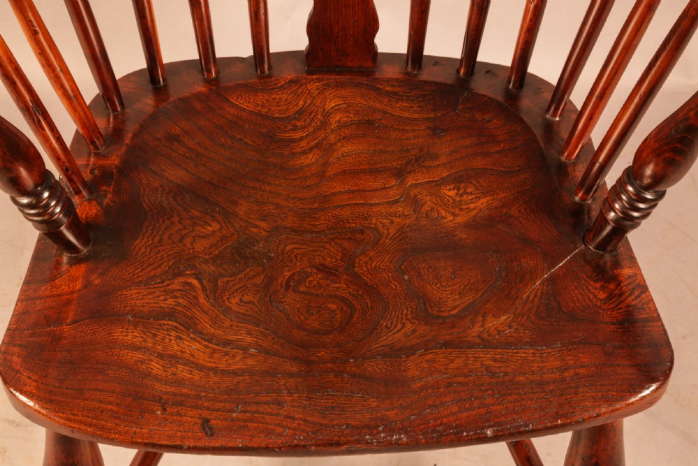 A nineteenth-century yew wood Windsor armchair featuring a curved hoop back, pierced central splat, turned arm supports, shaped saddle seat, and turned legs with a crinoline stretcher. View IX