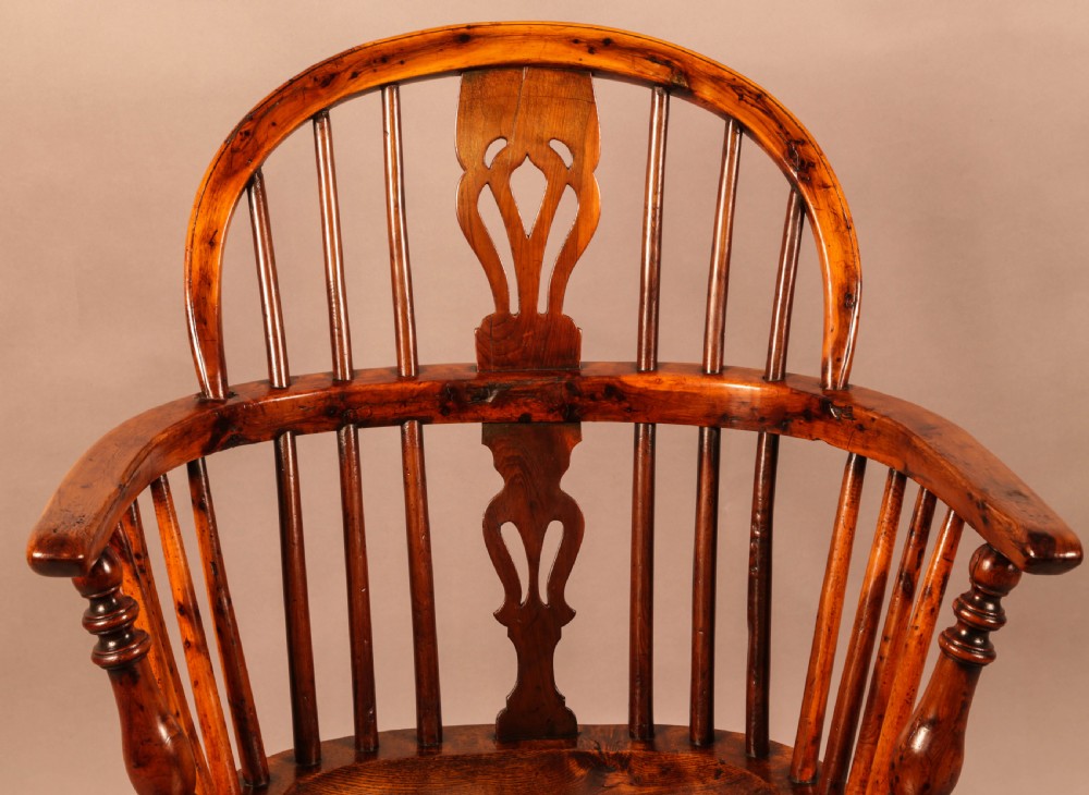 An antique yew wood low-back Windsor armchair featuring turned legs, a crinoline stretcher, and a pierced splat. View VI