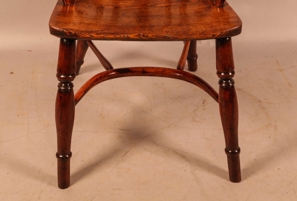 An antique yew wood low-back Windsor armchair featuring turned legs, a crinoline stretcher, and a pierced splat. View VII