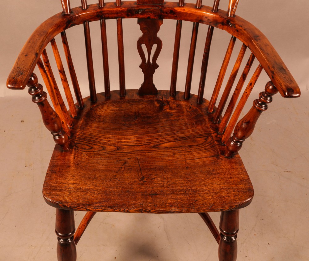 An antique yew wood low-back Windsor armchair featuring turned legs, a crinoline stretcher, and a pierced splat. View IX