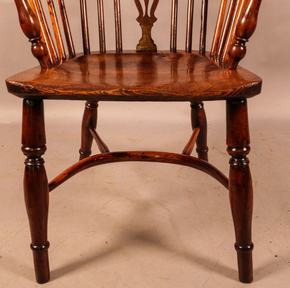 An antique yew wood low-back Windsor armchair featuring turned legs, a crinoline stretcher, and a pierced splat. View XI