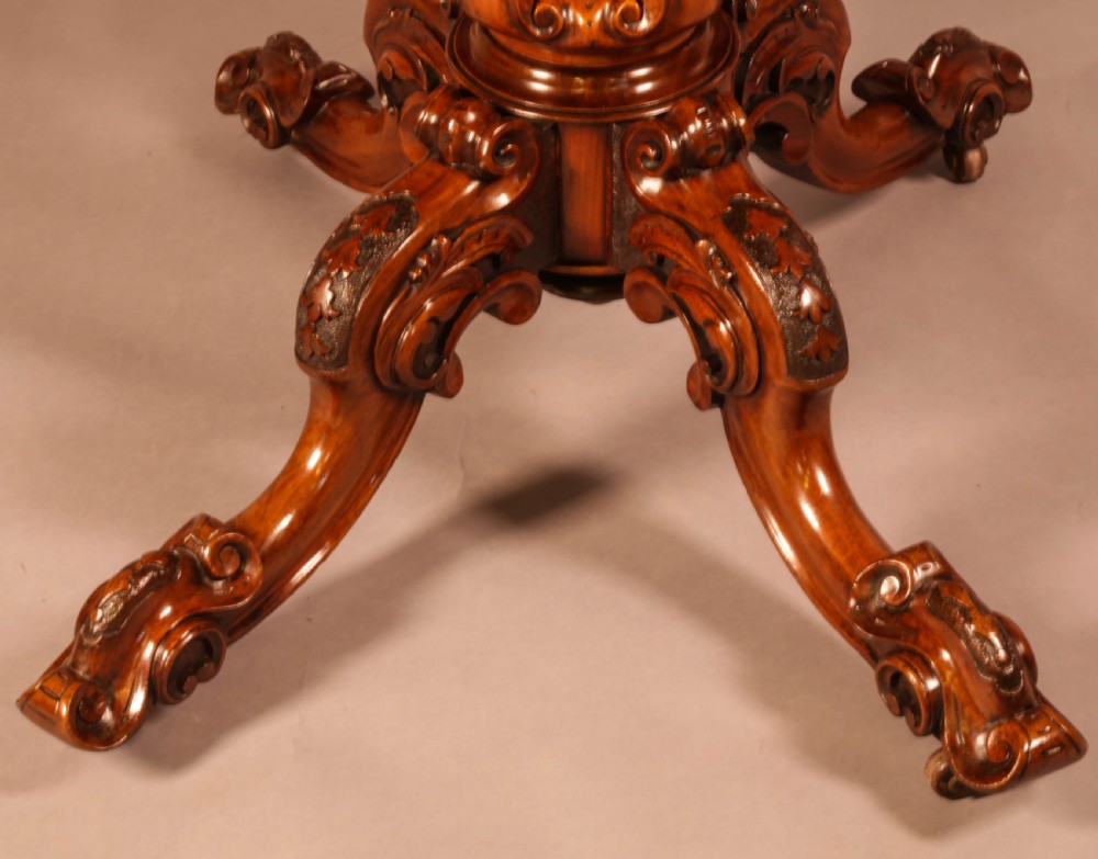 A Victorian burr walnut breakfast table featuring a shaped serpentine top resting on a central carved pedestal column with four scroll-carved legs. View XI