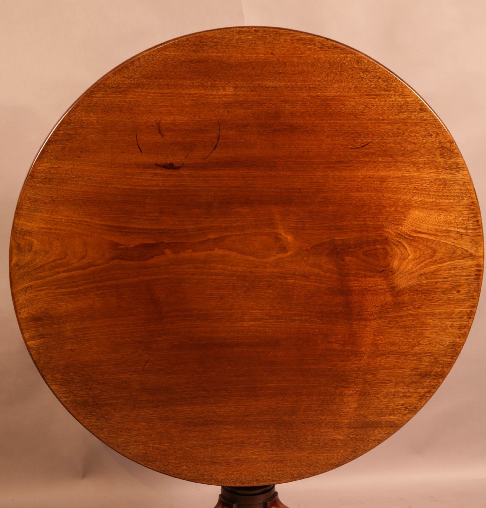 A circular mahogany tilt-top supper table supported by a turned central column and three cabriole legs. View II