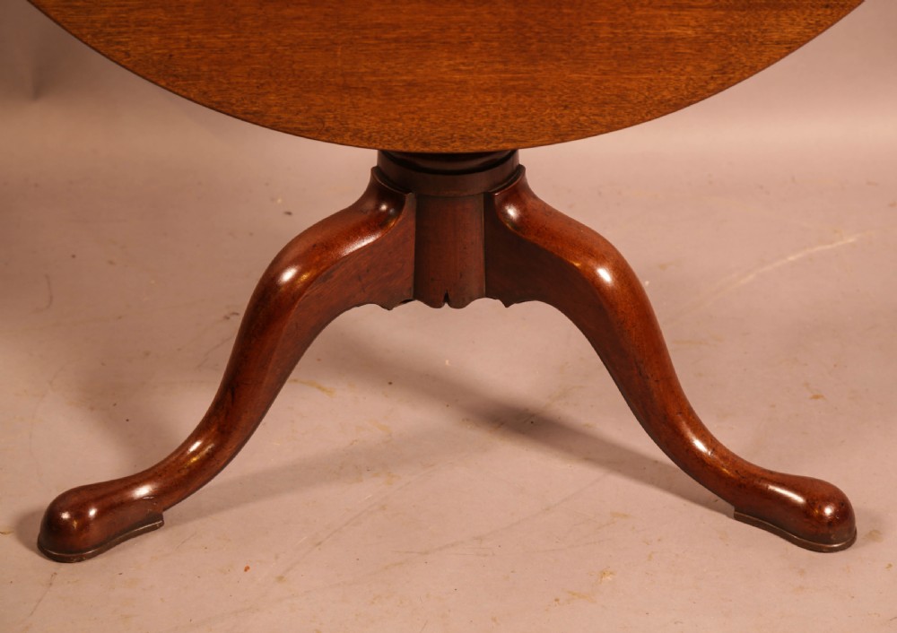 A circular mahogany tilt-top supper table supported by a turned central column and three cabriole legs. View III