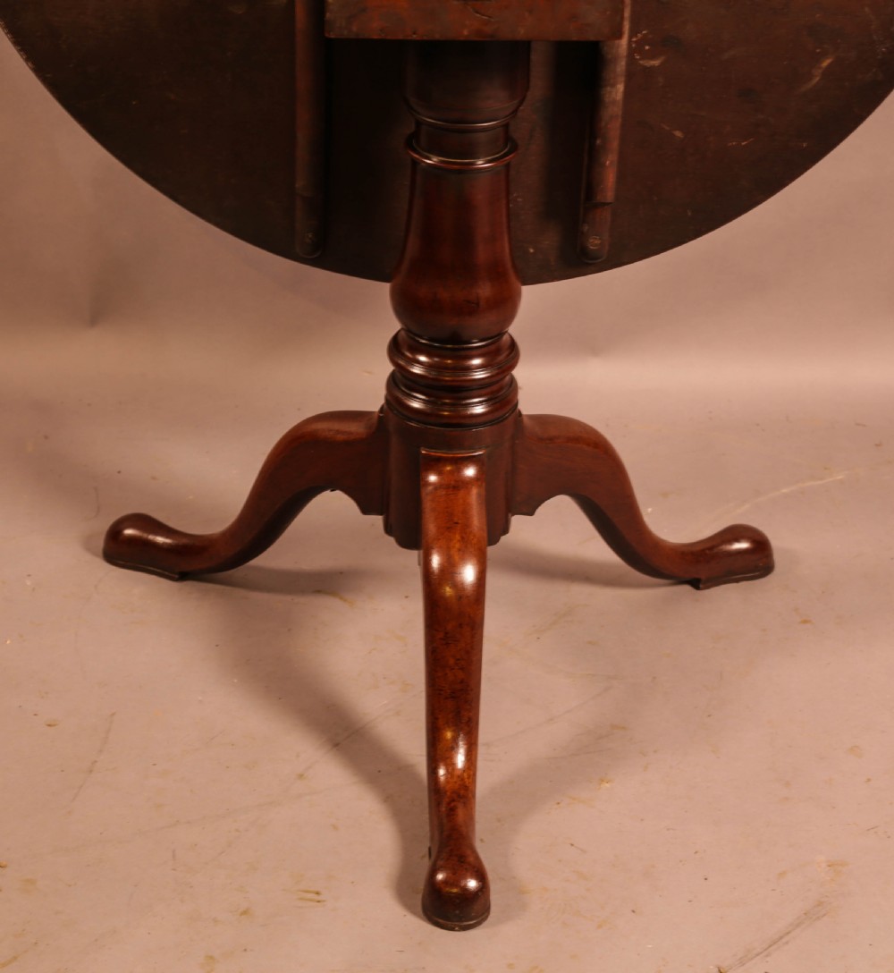 A circular mahogany tilt-top supper table supported by a turned central column and three cabriole legs. View IV