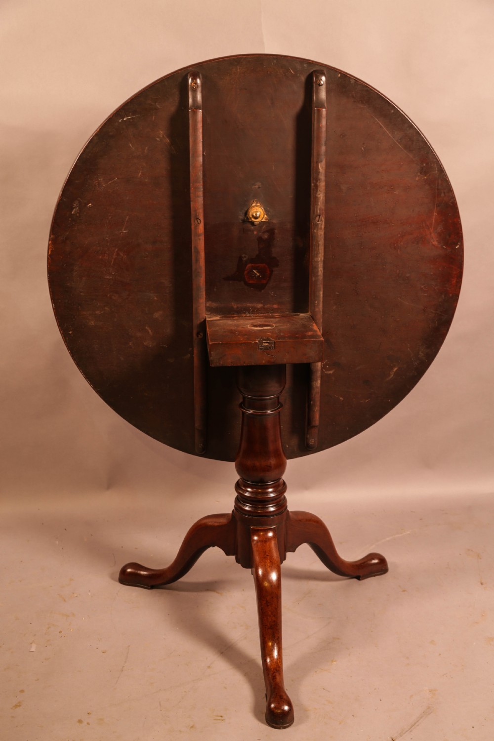 A circular mahogany tilt-top supper table supported by a turned central column and three cabriole legs. View V