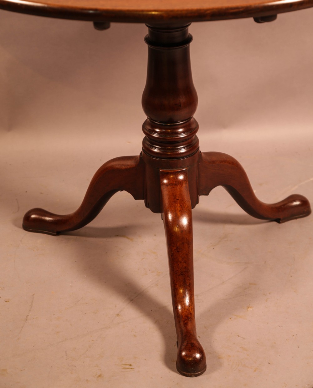 A circular mahogany tilt-top supper table supported by a turned central column and three cabriole legs. View VII