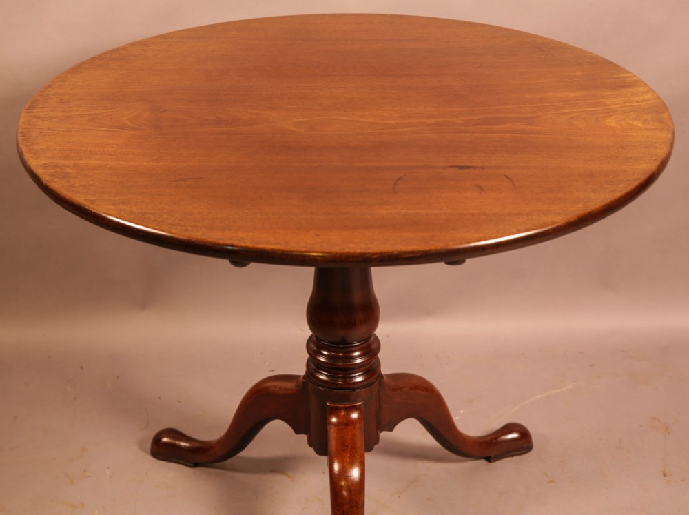 A circular mahogany tilt-top supper table supported by a turned central column and three cabriole legs. View VIII