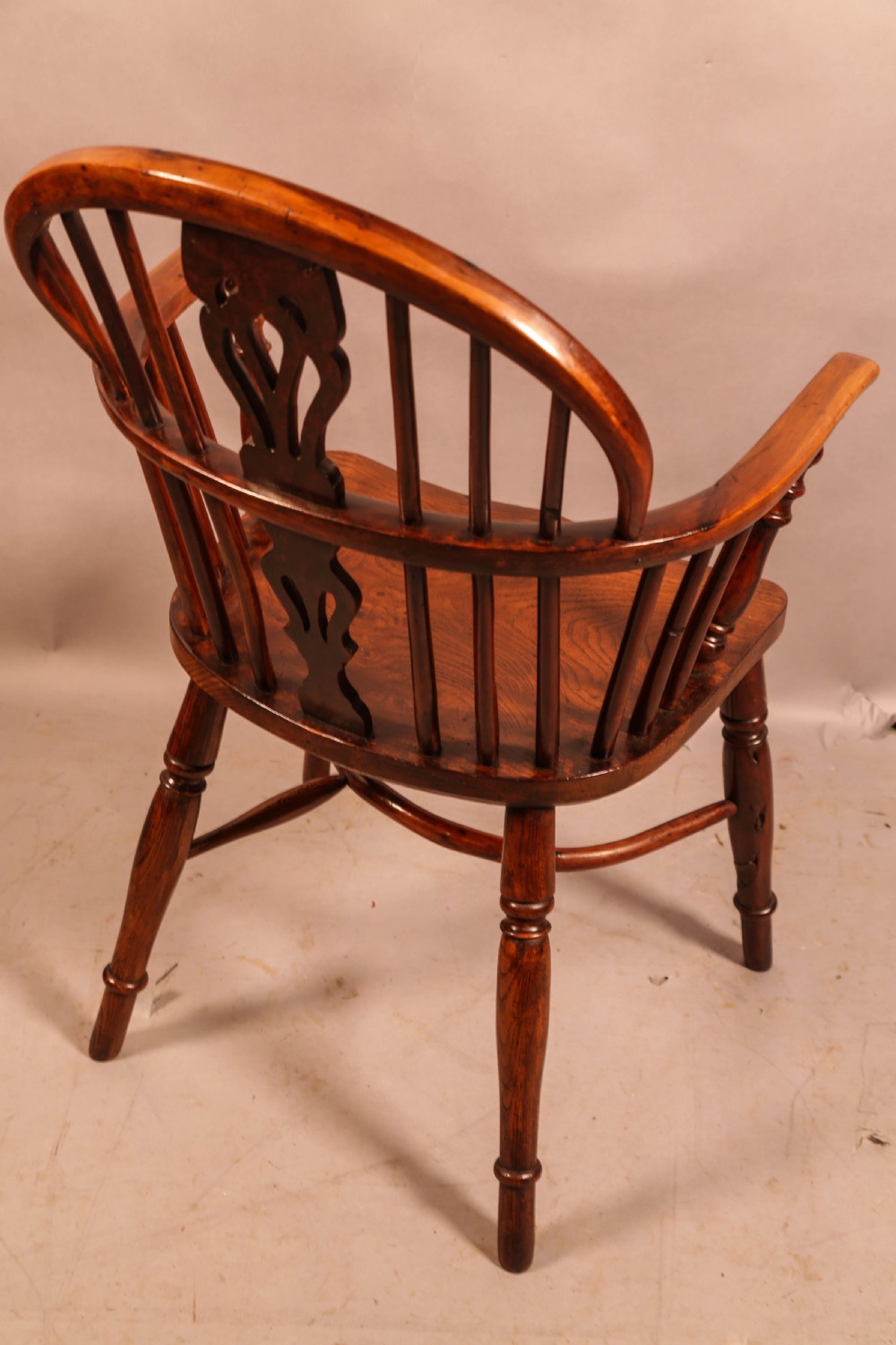 A low-back yew wood Windsor armchair featuring turned legs, a shaped seat, a pierced central back splat, and a curved crinoline stretcher. View III
