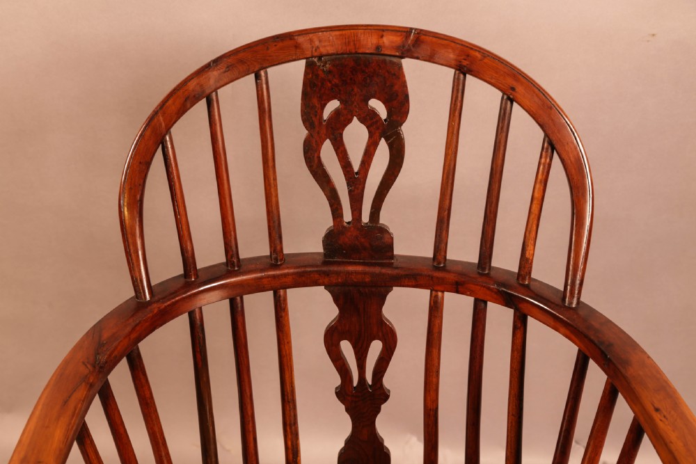 A low-back yew wood Windsor armchair featuring turned legs, a shaped seat, a pierced central back splat, and a curved crinoline stretcher. View VII