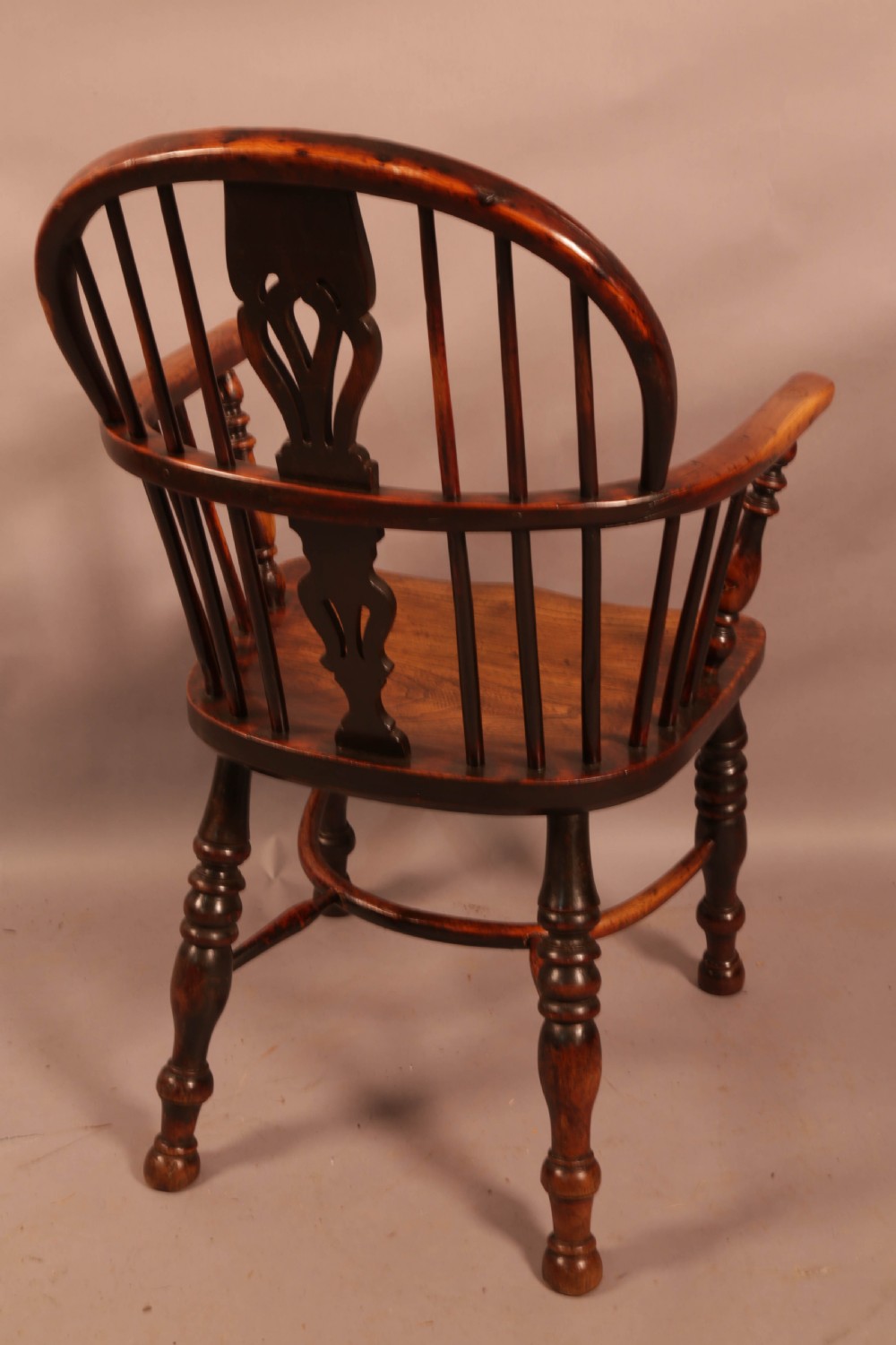 An antique yew wood Windsor armchair with a hoop back, pierced splat, curved armbow, turned legs, and a crinoline stretcher. View III