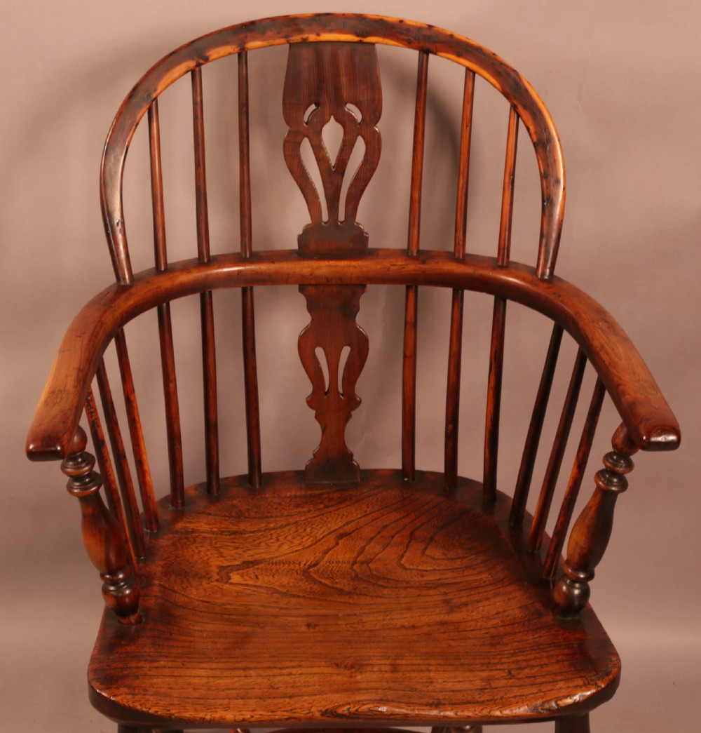 An antique yew wood Windsor armchair with a hoop back, pierced splat, curved armbow, turned legs, and a crinoline stretcher. View IV