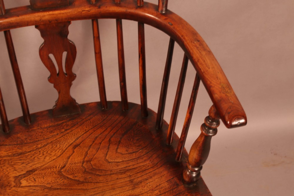 An antique yew wood Windsor armchair with a hoop back, pierced splat, curved armbow, turned legs, and a crinoline stretcher. View IX