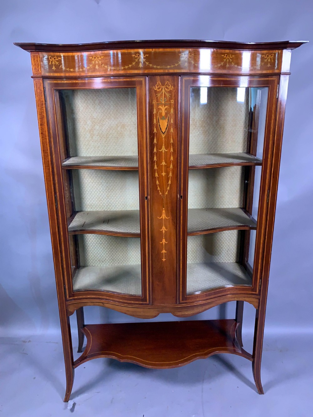 A Late Victorian Mahogany with inlay serpentine shape display cabinet