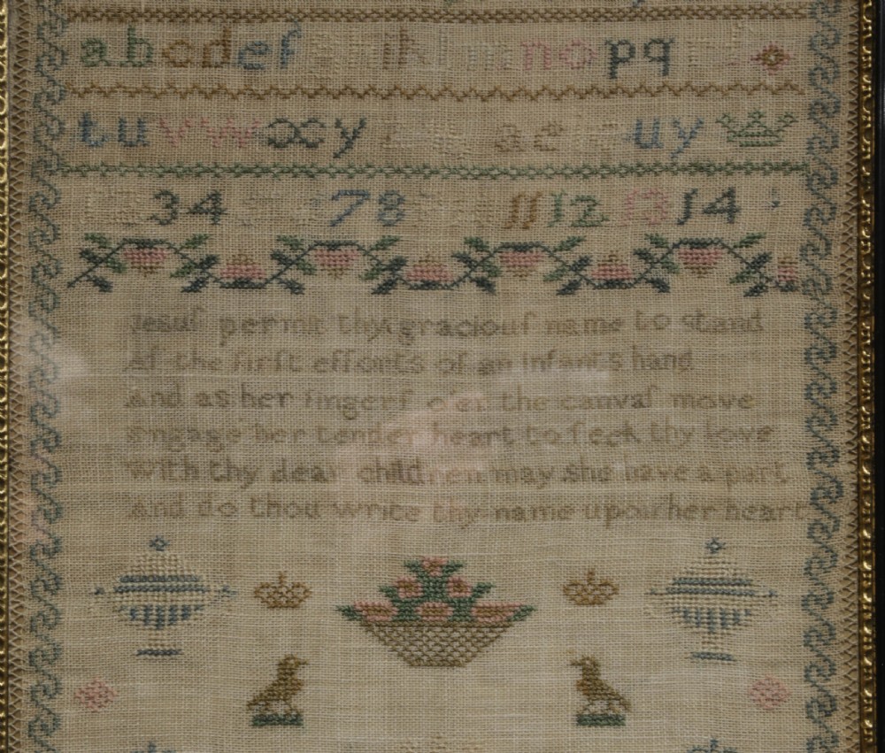 A framed 1820 Georgian needlework sampler featuring embroidered alphabets, numbers, crowns, and a central verse titled On Education on a linen ground. View II