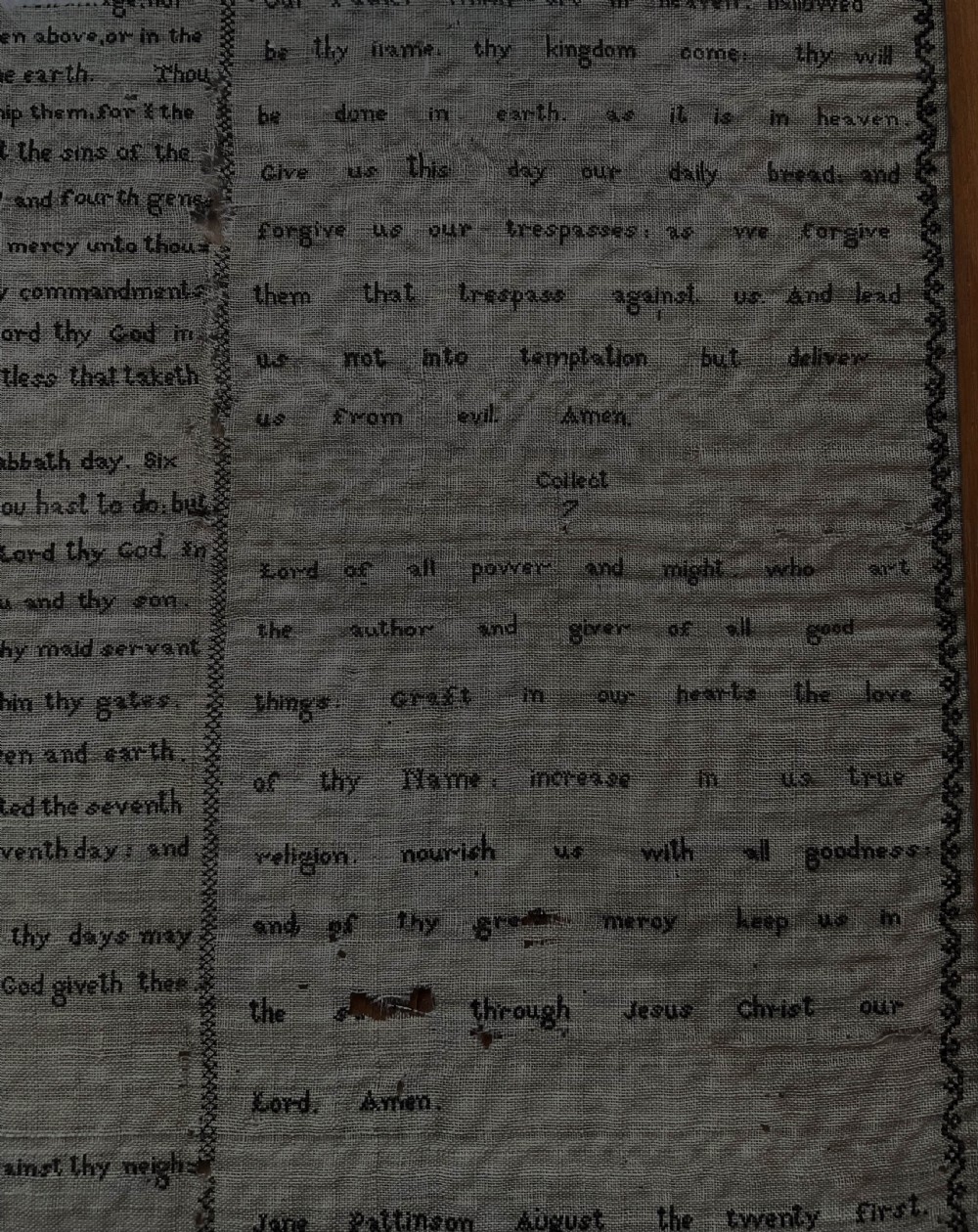An 1827 Georgian embroidered needlework sampler featuring the Ten Commandments, the Lords Prayer, and an alphabet border set in a wooden frame. View VI