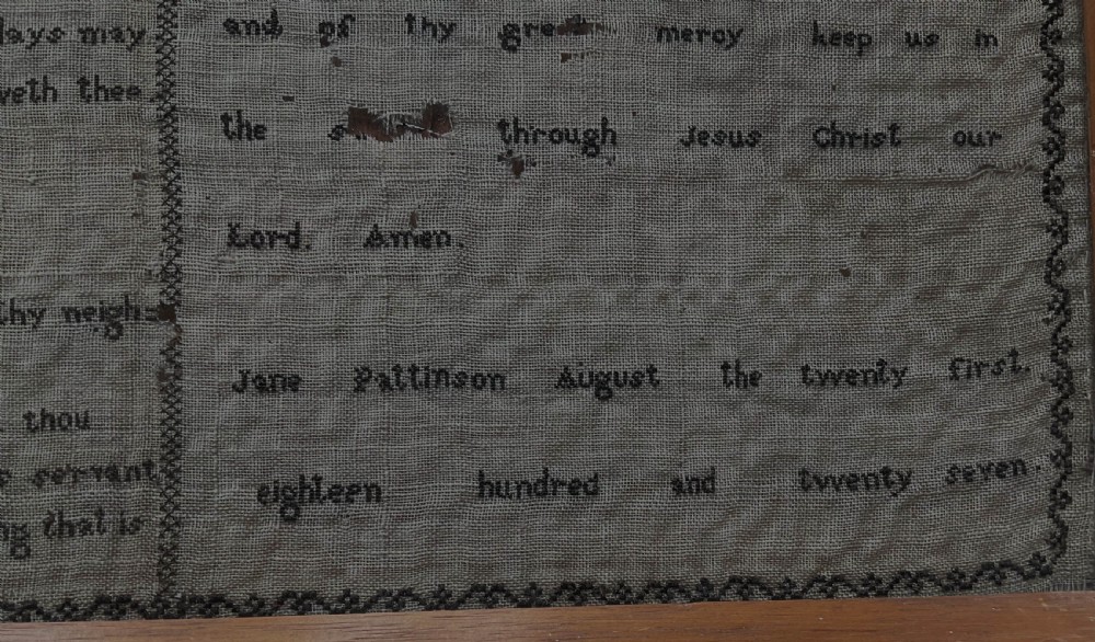 An 1827 Georgian embroidered needlework sampler featuring the Ten Commandments, the Lords Prayer, and an alphabet border set in a wooden frame. View VII