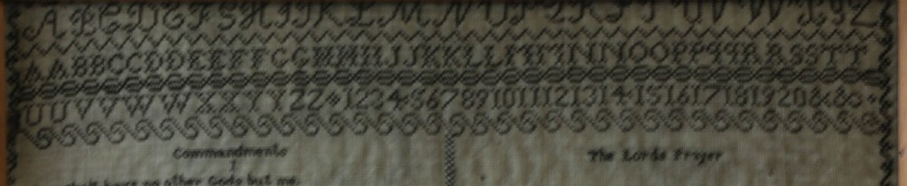 An 1827 Georgian embroidered needlework sampler featuring the Ten Commandments, the Lords Prayer, and an alphabet border set in a wooden frame. View IX