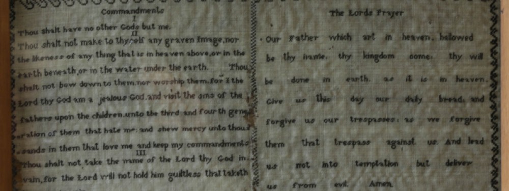 An 1827 Georgian embroidered needlework sampler featuring the Ten Commandments, the Lords Prayer, and an alphabet border set in a wooden frame. View X