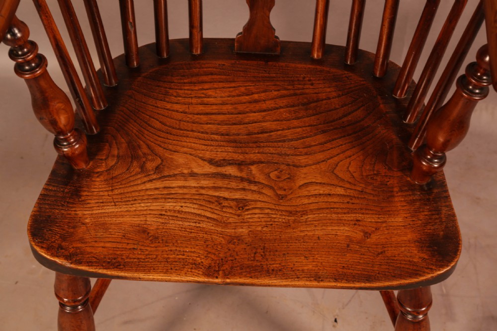 An antique yew wood low back Windsor armchair featuring a pierced central splat, steam-bent arm rail, turned legs, and a crinoline stretcher. View VIII