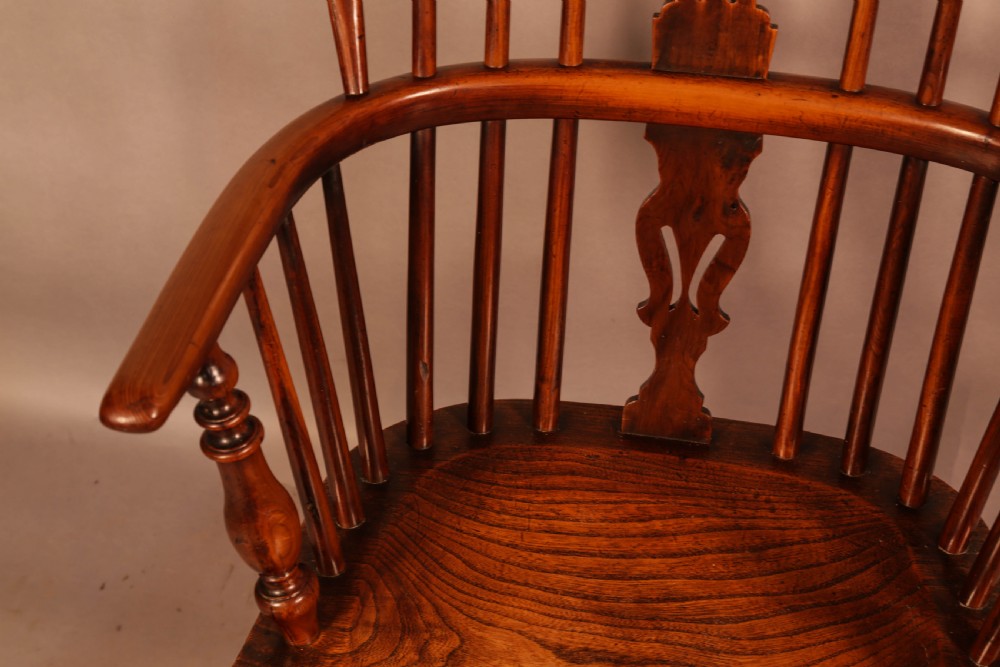 An antique yew wood low back Windsor armchair featuring a pierced central splat, steam-bent arm rail, turned legs, and a crinoline stretcher. View IX