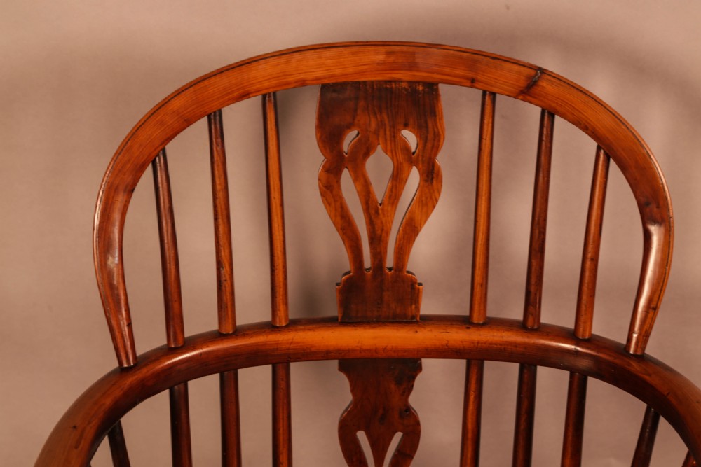 An antique yew wood low back Windsor armchair featuring a pierced central splat, steam-bent arm rail, turned legs, and a crinoline stretcher. View XI