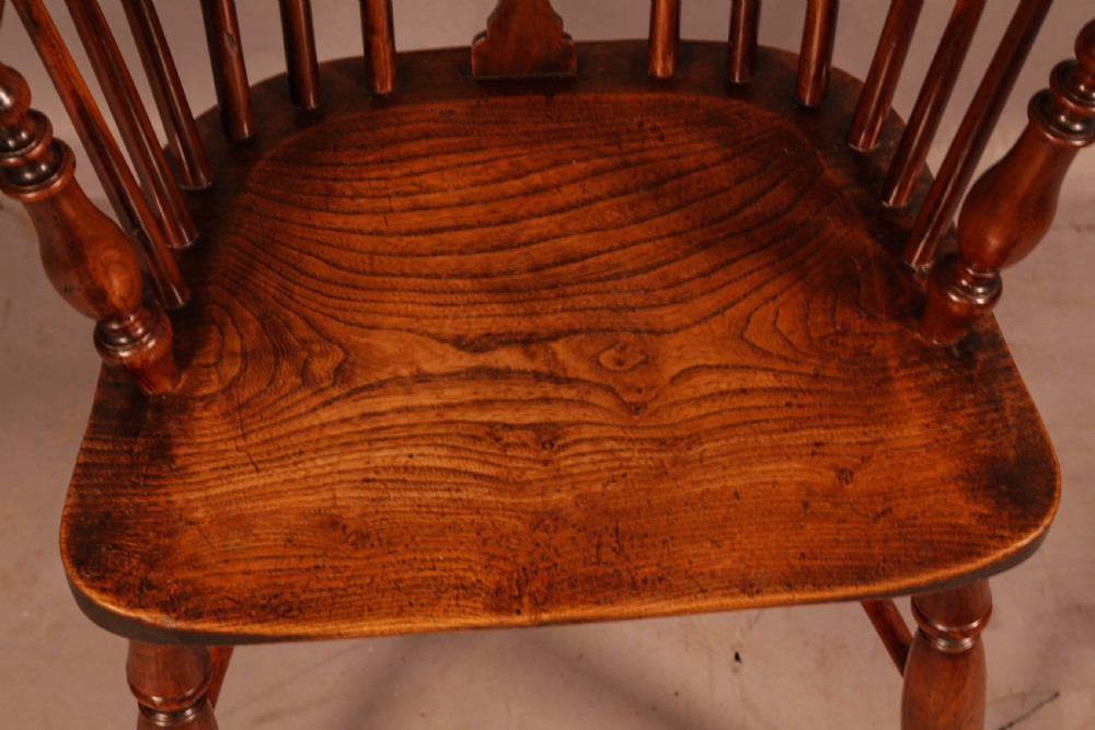 An antique yew wood low back Windsor armchair featuring a pierced central splat, steam-bent arm rail, turned legs, and a crinoline stretcher. View XII