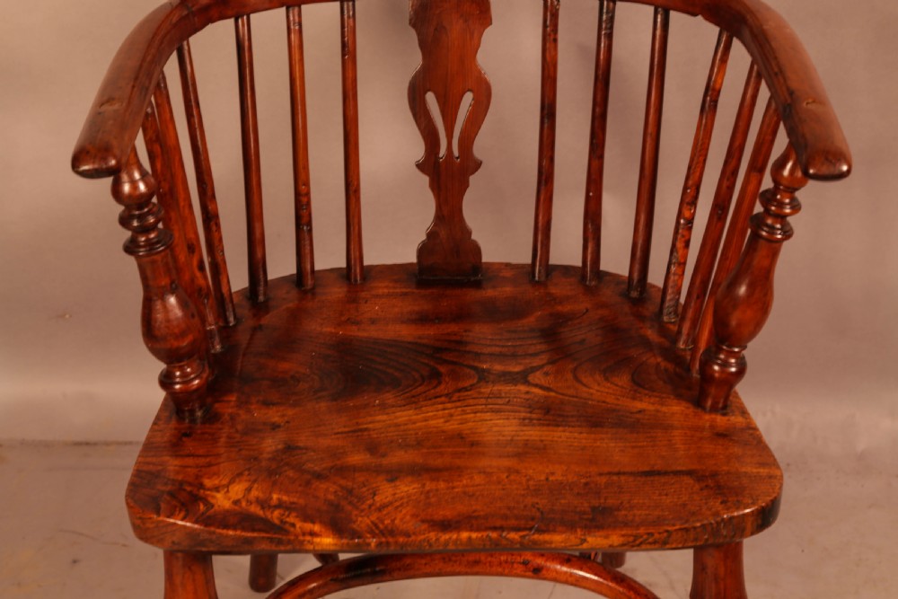 A low back yew wood Windsor armchair featuring turned spindles, a central pierced splat, a shaped seat, and a curved crinoline stretcher. View IV