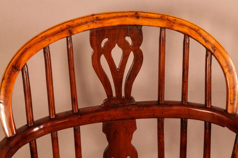 A low back yew wood Windsor armchair featuring turned spindles, a central pierced splat, a shaped seat, and a curved crinoline stretcher. View VIII