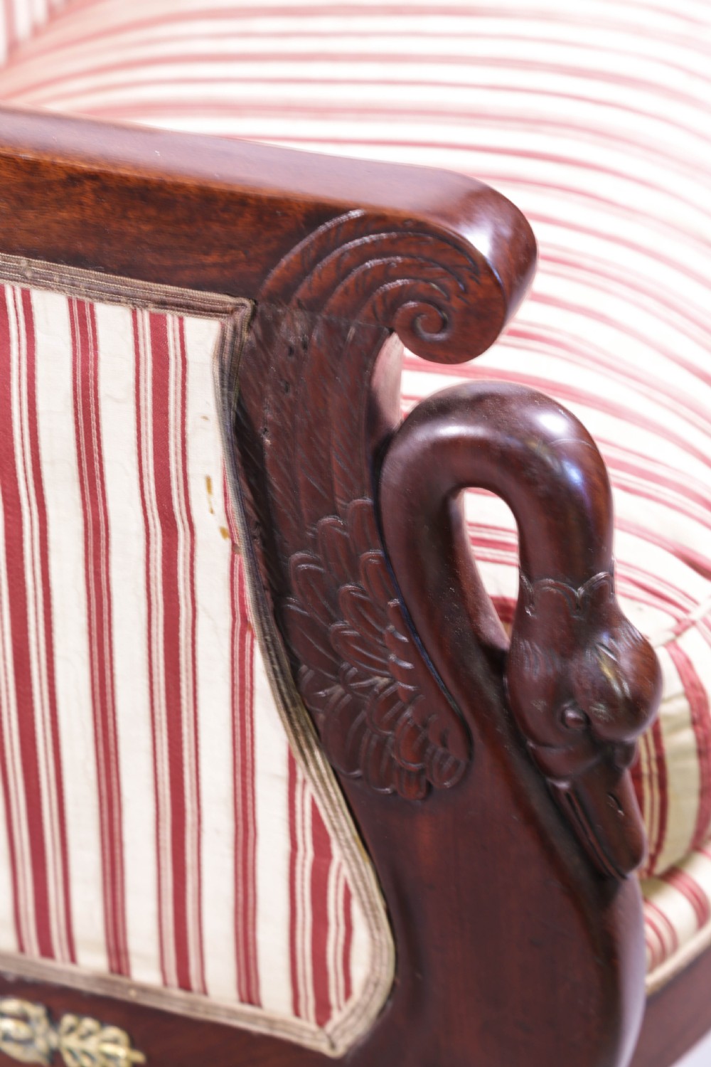 A Regency mahogany settee featuring a striped red and cream upholstered backrest and seat cushion, accented with gilded decorative carvings along the wooden frame. View V