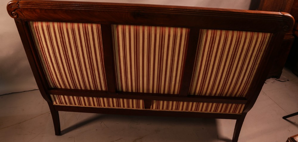 A Regency mahogany settee featuring a striped red and cream upholstered backrest and seat cushion, accented with gilded decorative carvings along the wooden frame. View VIII