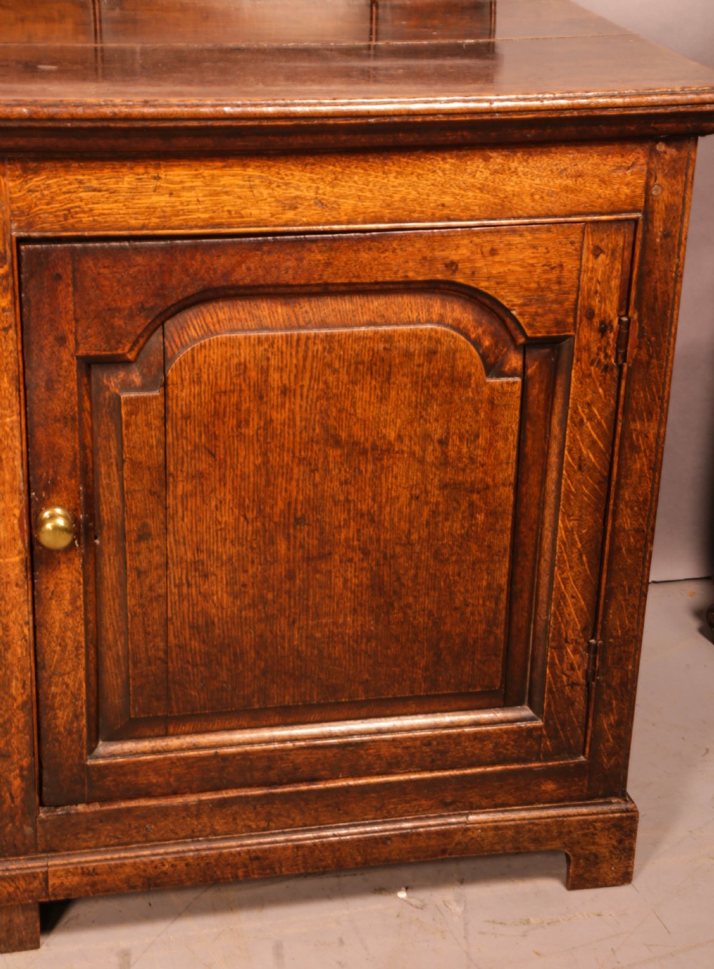 A large antique Georgian oak serving dresser featuring central drawers flanked by panelled cupboards and a stepped top shelf with small drawers. View IX