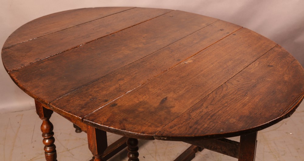 A seventeenth-century oak gateleg dining table featuring two drop leaves, turned legs, perimeter stretchers, and an open end drawer. View III