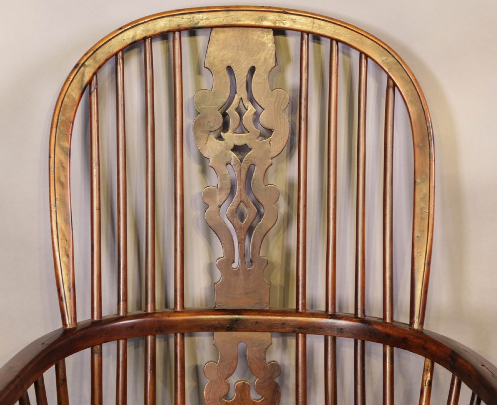 A high-back wooden Windsor armchair featuring a bentwood hoop, pierced central splat, turned spindles, sculpted seat, and baluster legs connected by a stretcher. View VI