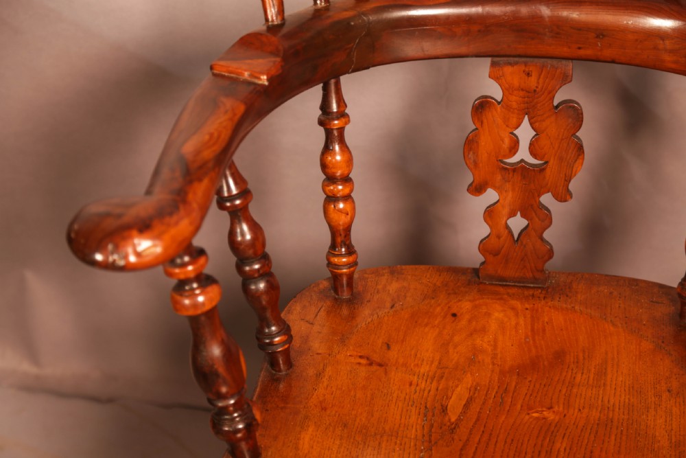 A 19th-century yew wood Windsor armchair featuring a curved hoop back, central pierced splat, turned spindles, broad armrests, and turned legs. View VI