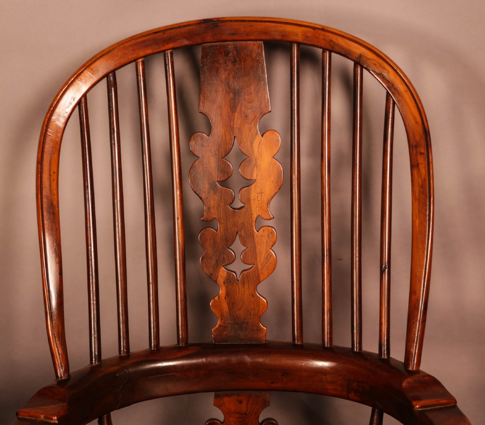 A 19th-century yew wood Windsor armchair featuring a curved hoop back, central pierced splat, turned spindles, broad armrests, and turned legs. View VII