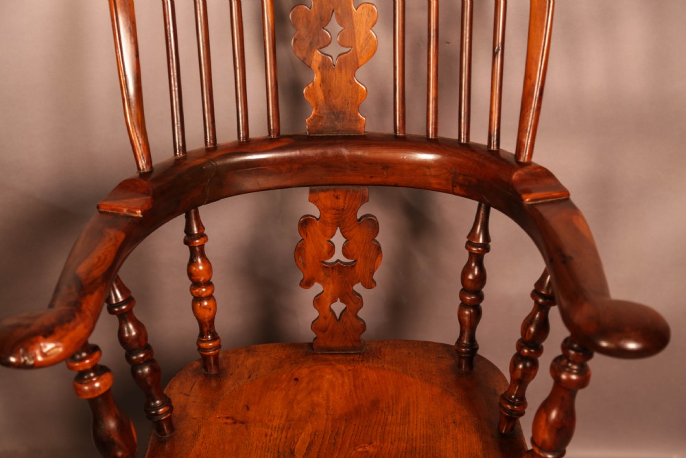 A 19th-century yew wood Windsor armchair featuring a curved hoop back, central pierced splat, turned spindles, broad armrests, and turned legs. View VIII