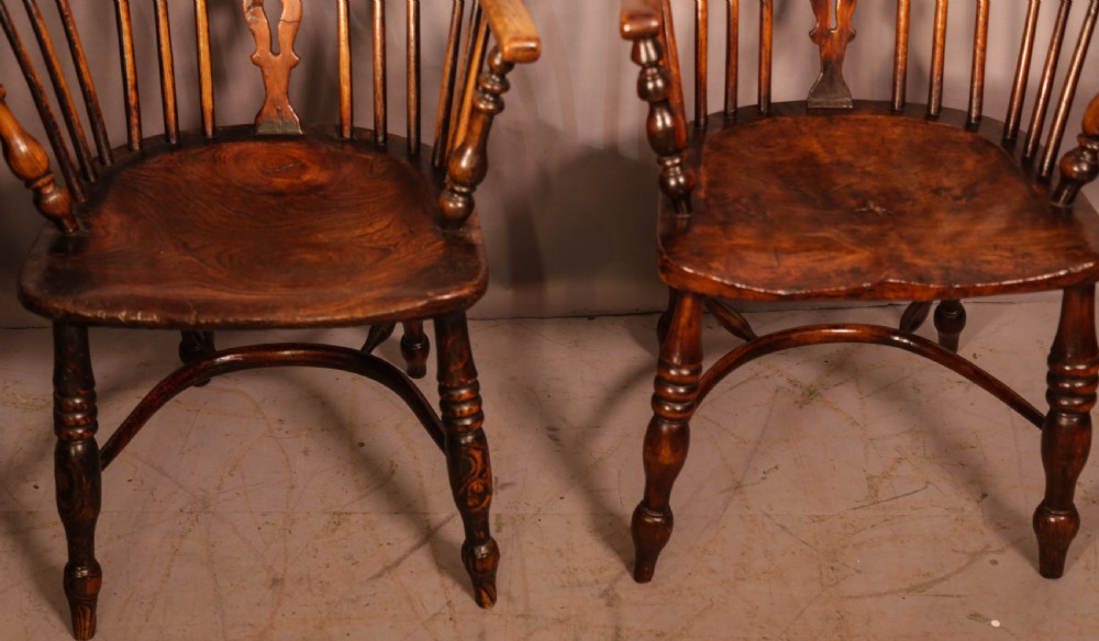 Two antique wooden armchairs featuring curved backrests, central pierced splats, spindle supports, and solid saddle seats. View II