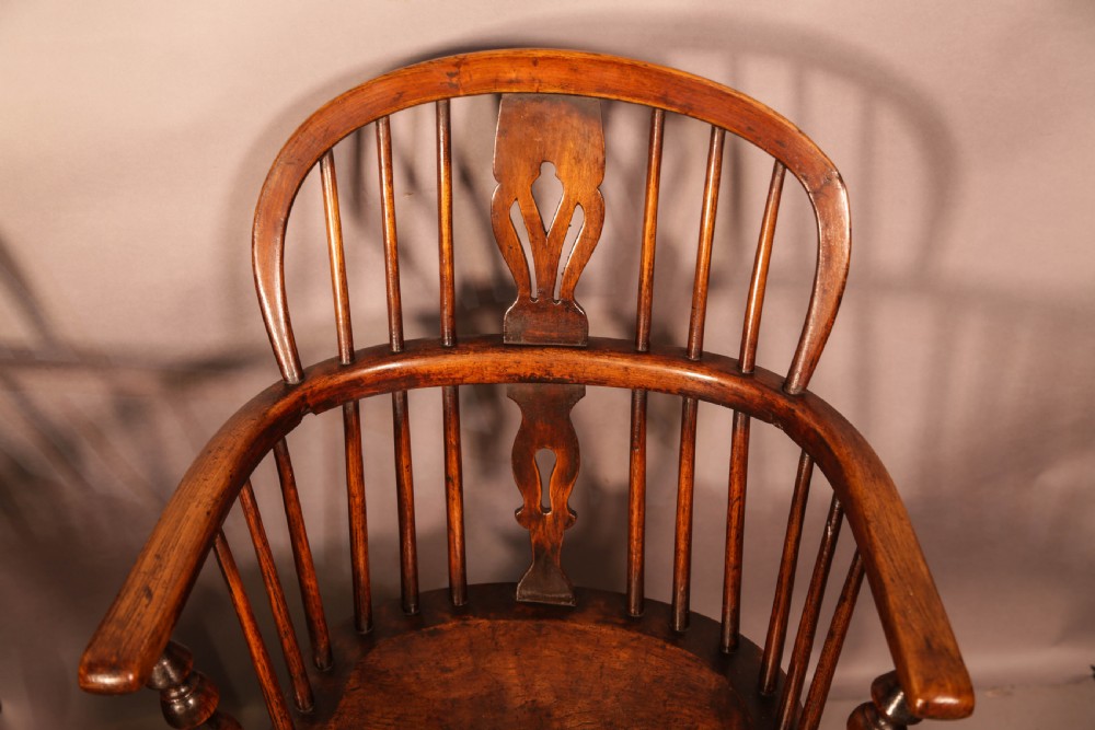 Two antique wooden armchairs featuring curved backrests, central pierced splats, spindle supports, and solid saddle seats. View IX