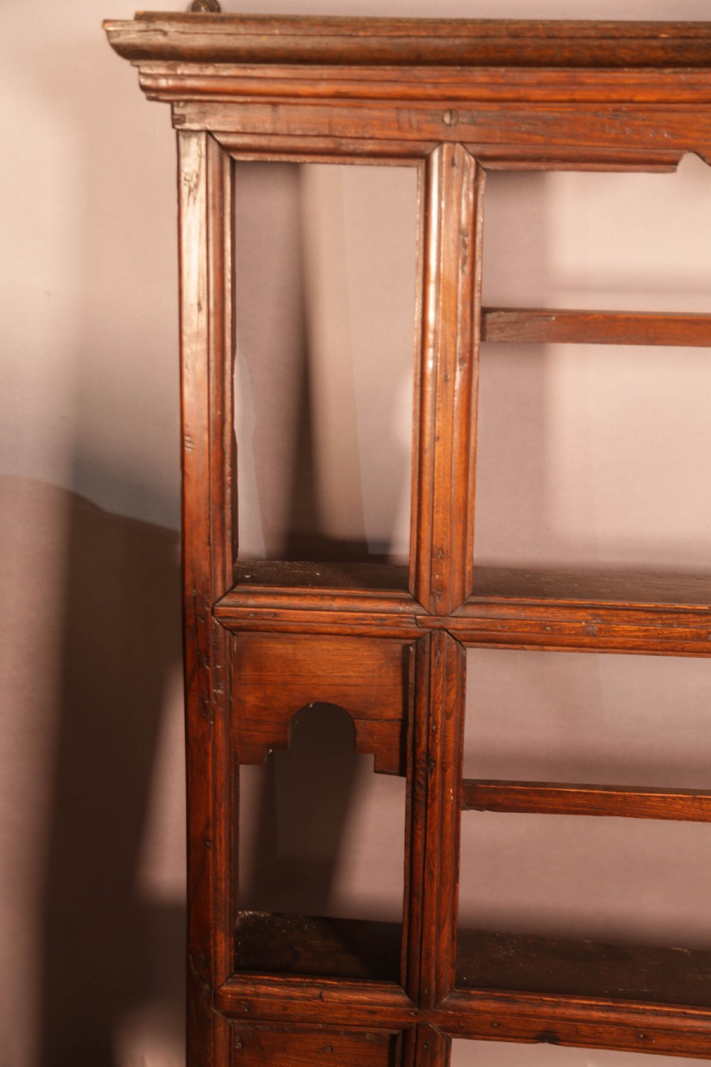 A Georgian dark oak plate rack featuring a scalloped top frieze, horizontal retaining bars, and side alcoves with shaped arch cutouts. View VII
