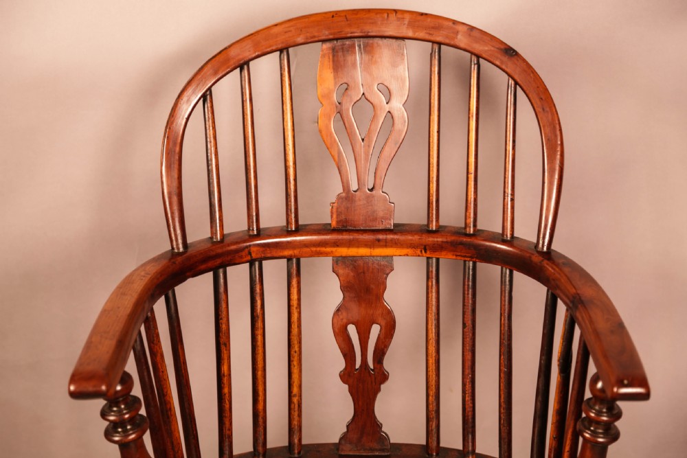 A yew wood Windsor armchair featuring a low back with turned spindles, a pierced fretwork central splat, curved armrests, a shaped solid seat, and turned legs joined by a crinoline stretcher. View VI