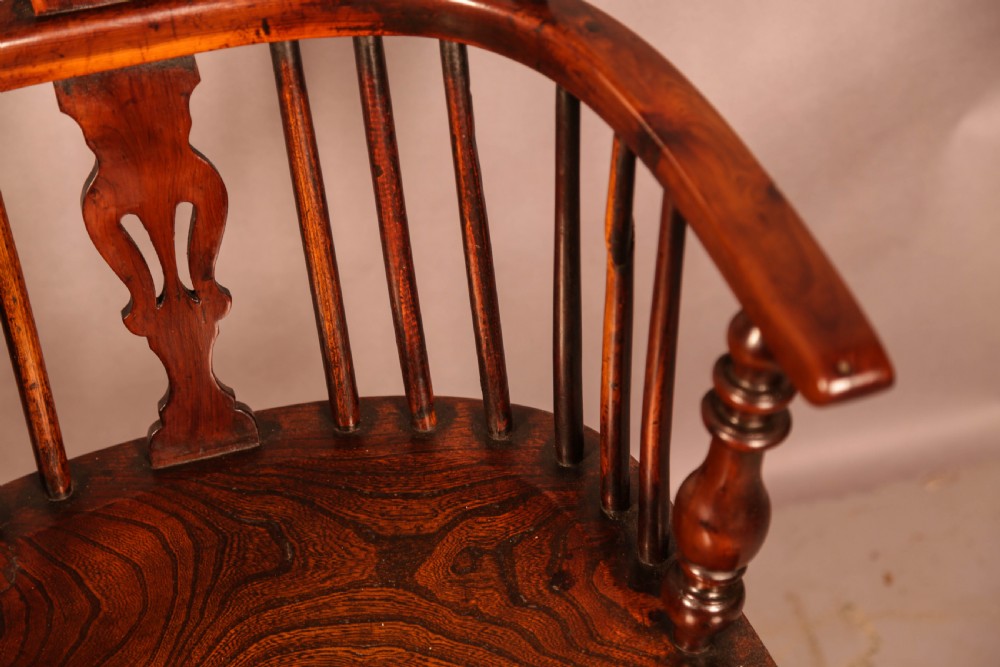 A yew wood Windsor armchair featuring a low back with turned spindles, a pierced fretwork central splat, curved armrests, a shaped solid seat, and turned legs joined by a crinoline stretcher. View VIII