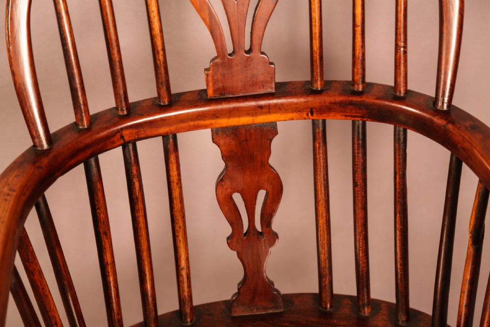 A yew wood Windsor armchair featuring a low back with turned spindles, a pierced fretwork central splat, curved armrests, a shaped solid seat, and turned legs joined by a crinoline stretcher. View IX