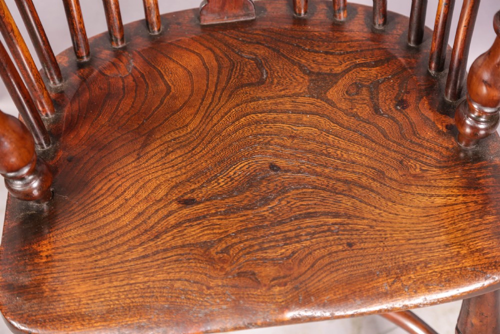 A yew wood Windsor armchair featuring a low back with turned spindles, a pierced fretwork central splat, curved armrests, a shaped solid seat, and turned legs joined by a crinoline stretcher. View XI