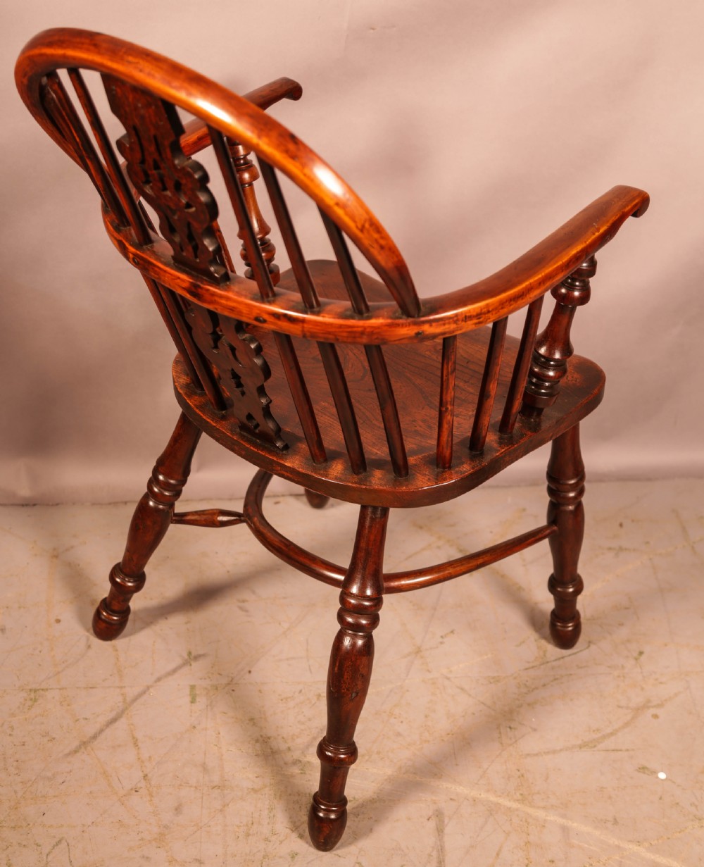 An antique yew wood Windsor armchair featuring a pierced splat, spindle back, shaped wooden seat, and turned legs. View II