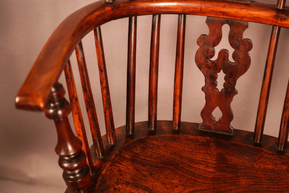 An antique yew wood Windsor armchair featuring a pierced splat, spindle back, shaped wooden seat, and turned legs. View VI