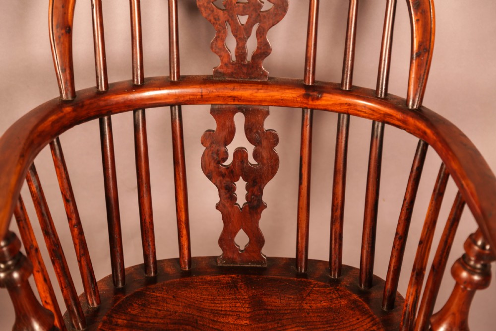 An antique yew wood Windsor armchair featuring a pierced splat, spindle back, shaped wooden seat, and turned legs. View VIII