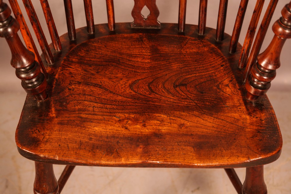 An antique yew wood Windsor armchair featuring a pierced splat, spindle back, shaped wooden seat, and turned legs. View XI