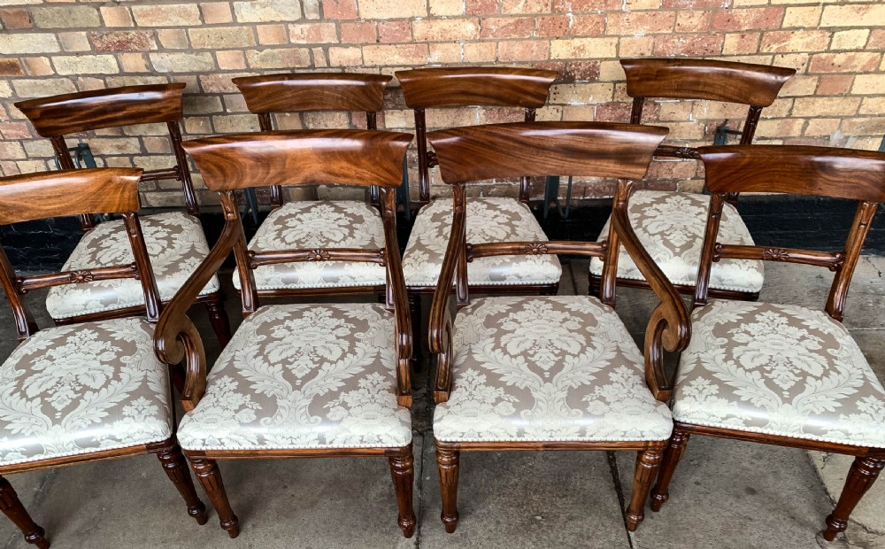 A set of eight Victorian mahogany dining chairs featuring curved top rails and patterned upholstered seats arranged in rows. View II