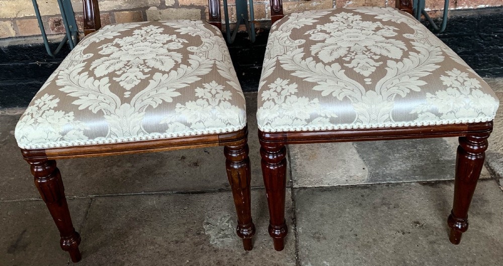 A set of eight Victorian mahogany dining chairs featuring curved top rails and patterned upholstered seats arranged in rows. View VII
